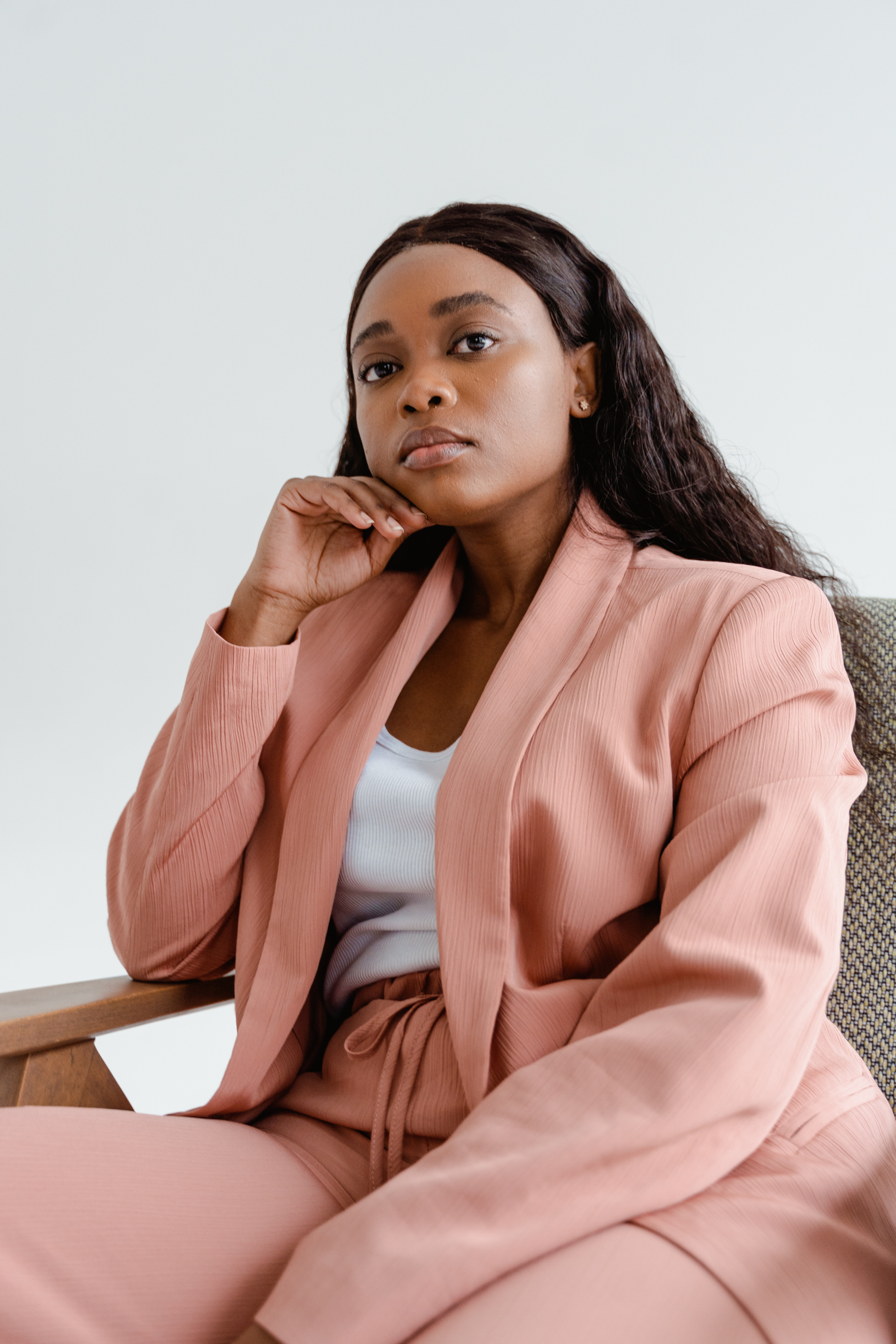 Woman in Pink Business Suit Sitting on Chair